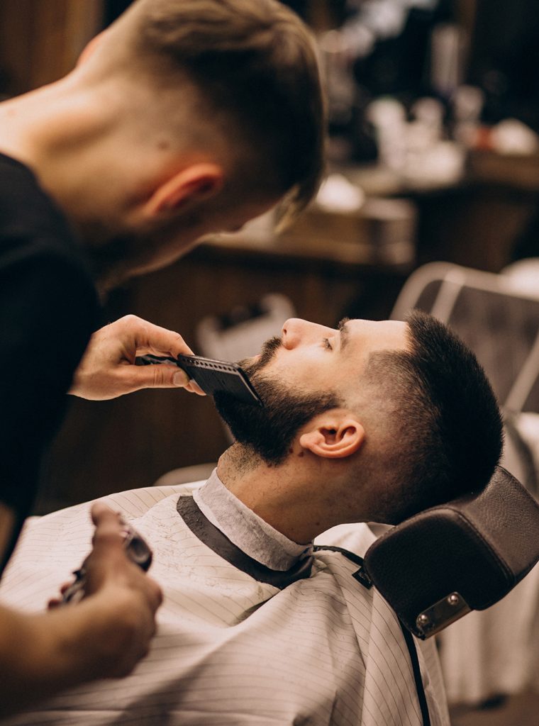 Man at a barbershop salon doing haircut and beard trim